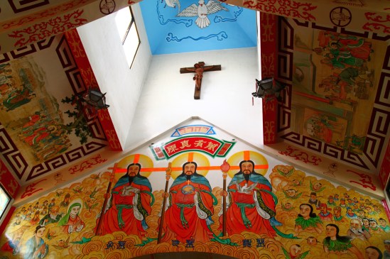 [Looking up at the sanctuary, we see a Chinese depiction of the Holy Trinity: God the Father in the center, God the Son (left), and God the Holy Spirit (right).]